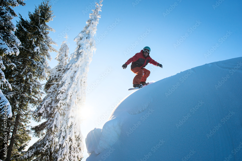Freeride snowboarder riding on dangerous slope. Blue sky and sun on the background copyspace Freeride snowboarder riding on dangerous slope. Blue sky and sun on the background copyspace