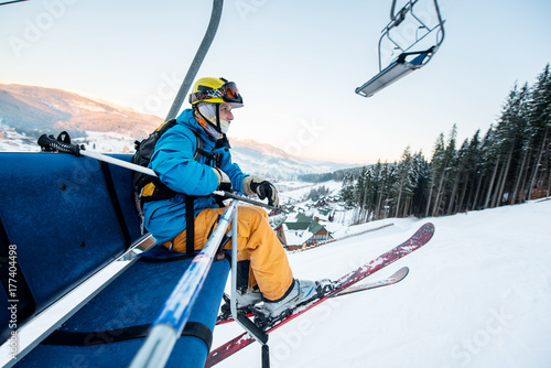 Shot of a skier sitting on a ski lift chair riding up to the top of the mountain copyspace winter extreme sports concept