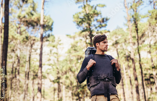 Man hiking in forest wearing a backpack