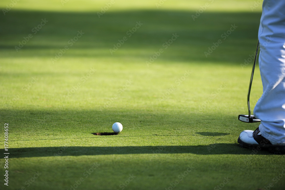 Obraz premium Golf ball about to drop in the hole. 