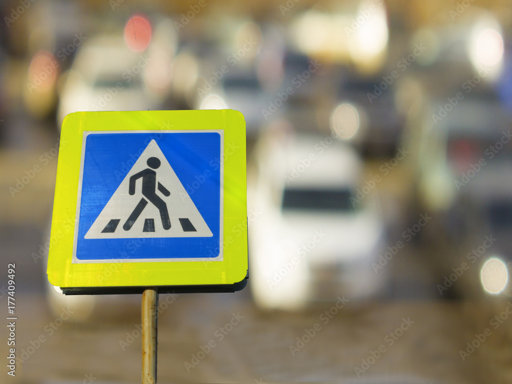 sign pedestrian crossing against the background of cars on the road.