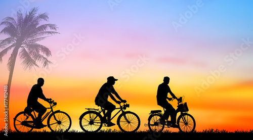 Silhouette man and bike relaxing with sunrise background.