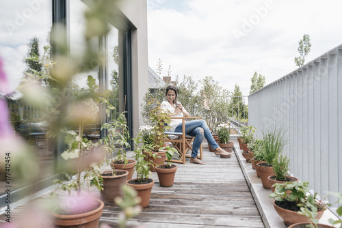 Smiling woman relaxing on balcony photo