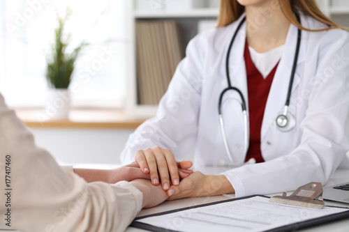 Hand of doctor  reassuring her female patient