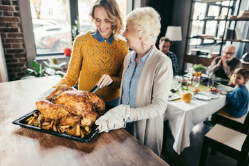 senior mother and daughter with thanksgiving turkey