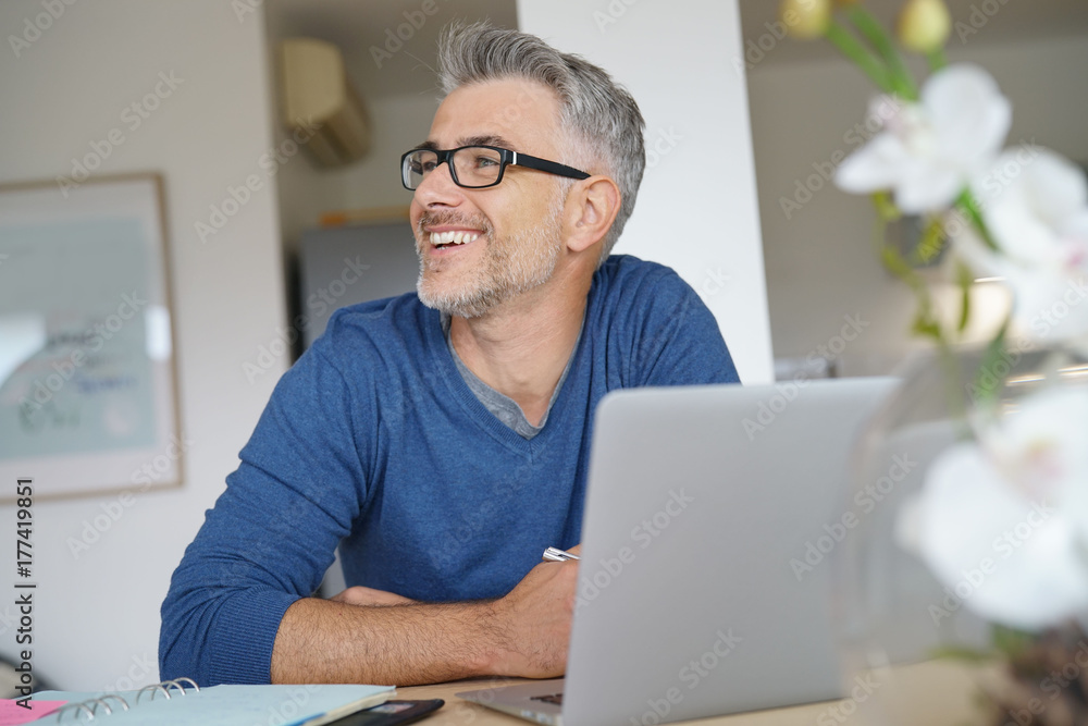 Middle-aged man working from home-office on laptop Middle-aged man working from home-office on laptop