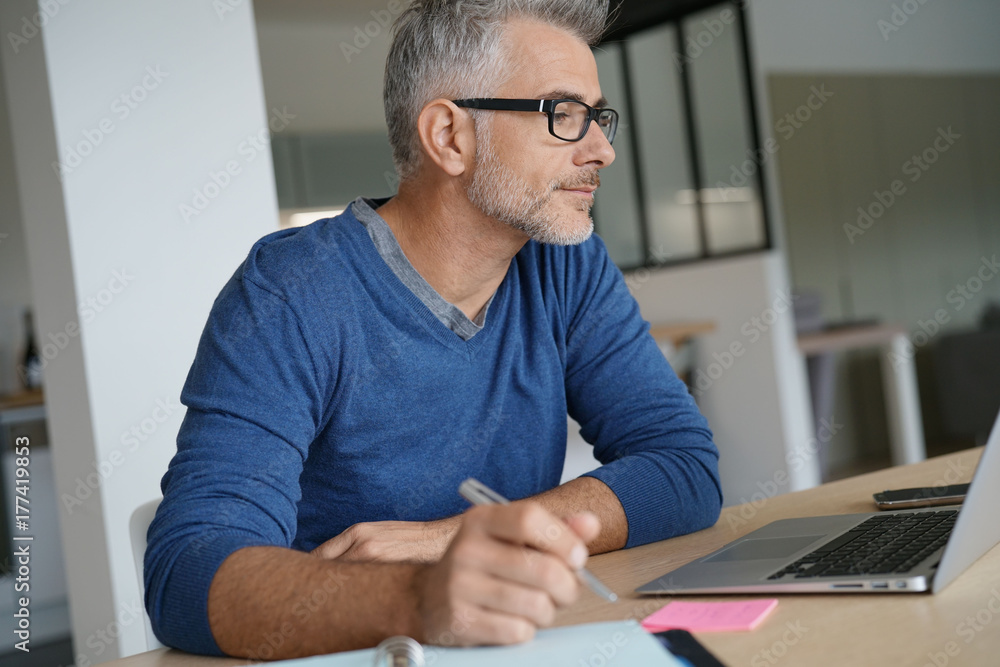 Middle-aged man working from home-office on laptop Middle-aged man working from home-office on laptop