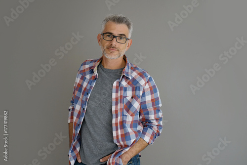 Casual man with grey hair standing on background, isolated
