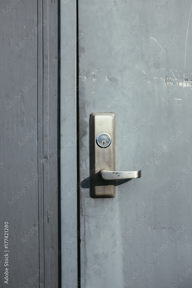 Grey door and lock on building exterior Grey door and lock on building exterior