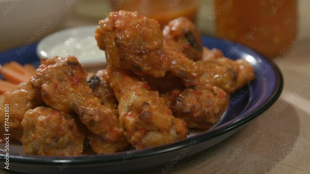 Chicken Wings on Plate Panning Shot Close Up. a panning left and right close up view of tasty chicken wings on a blue plate with carrots and blue cheese
Chicken Wings on Plate Panning Shot Close Up. a panning left and right close up view of tasty chicken wings on a blue plate with carrots and blue cheese
