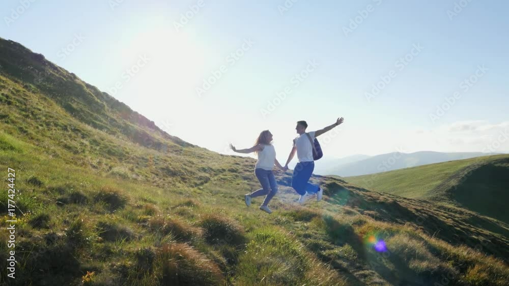 Couple have fun and jumping on the mountain meadow Couple have fun and jumping on the mountain meadow