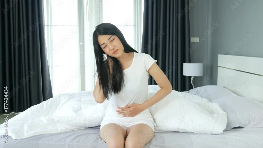 4k of Young woman sitting on the bed with pain 4k of Young woman sitting on the bed with pain