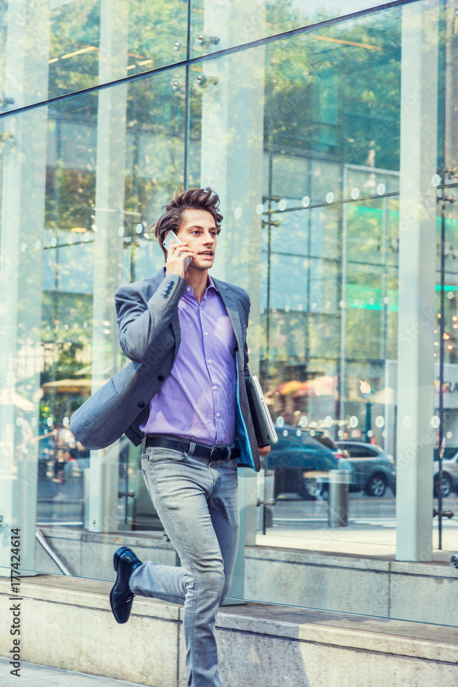 Hurry Up. Young businessman wearing gray blazer, patterned shirts, jeans,  black leather shoes, carrying laptop computer, talking on cell phone,  running on street in Manhattan, New York.. Stock-Foto | Adobe Stock