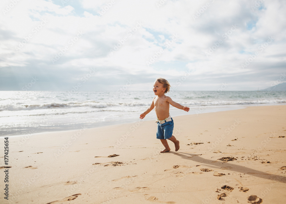 Toddler boy running on sandy tropical beach alone Toddler boy running on sandy tropical beach alone