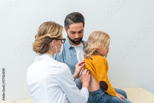 doctor listening to breath of little girl