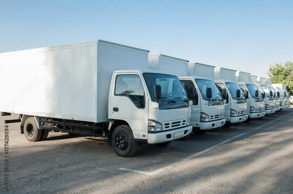white cargo vehicles stand in a row on a parking. freight transportation. truck park white cargo vehicles stand in a row on a parking. freight transportation. truck park
