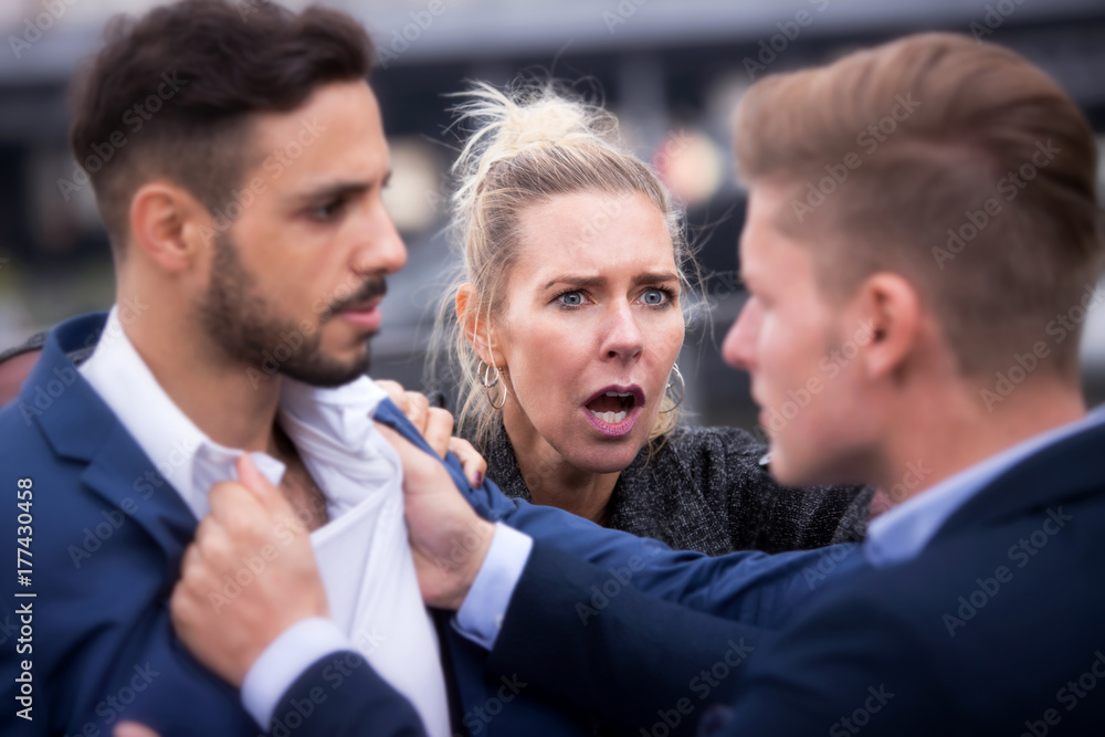 two man fighting while a woman is trying to intervene two man fighting while a woman is trying to intervene