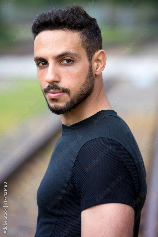 young man standing outside next to train tracks young man standing outside next to train tracks