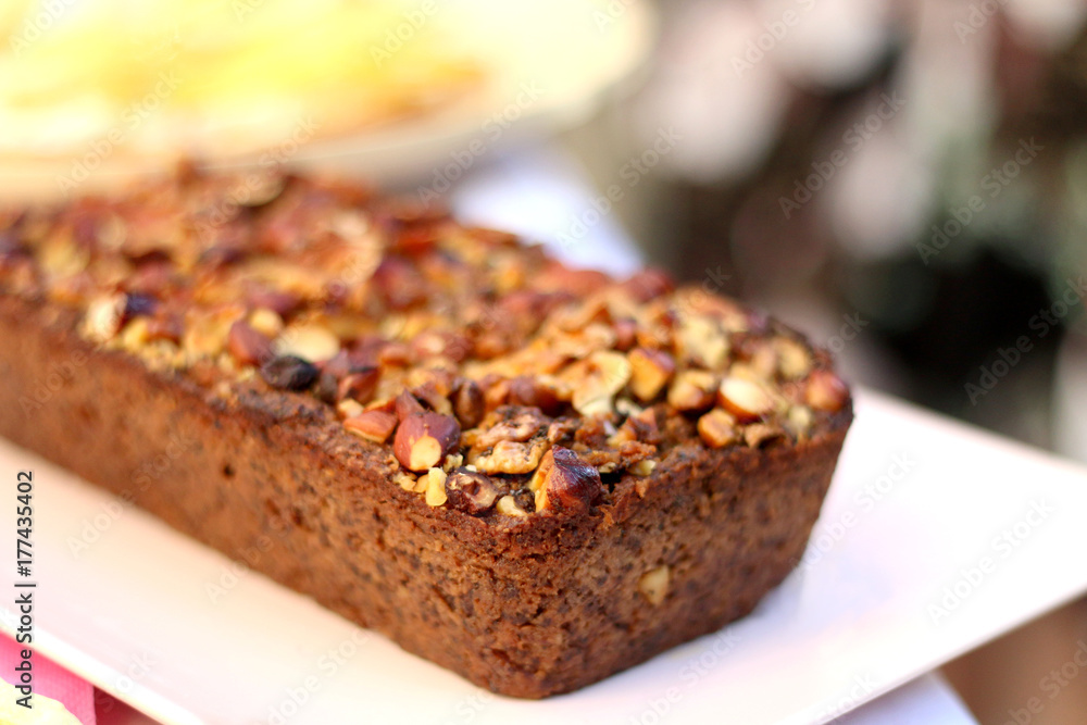 Banana bread decorated with hazelnuts. Selective focus. 
