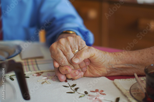 85 years old couple in love holding hands photo
