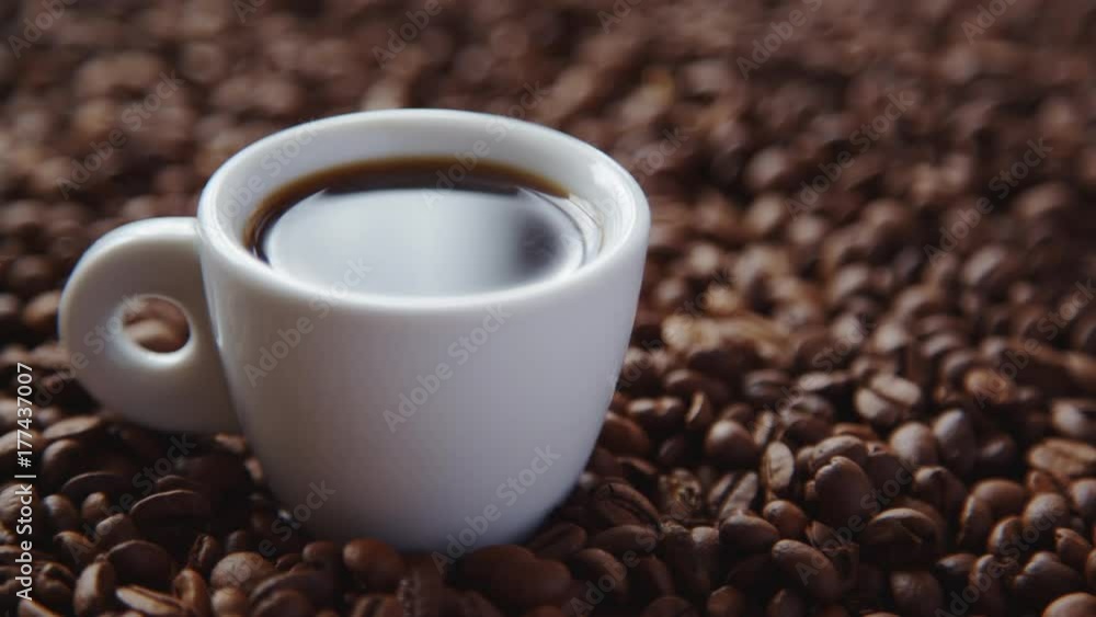 Hot coffee and roasted coffee beans on the table Hot coffee and roasted coffee beans on the table