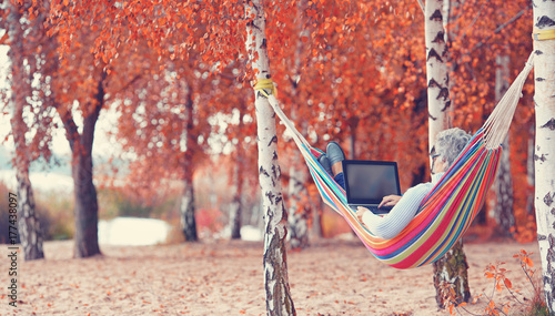 Foto arbeiten in der Natur, mit Laptop in der Hängematte