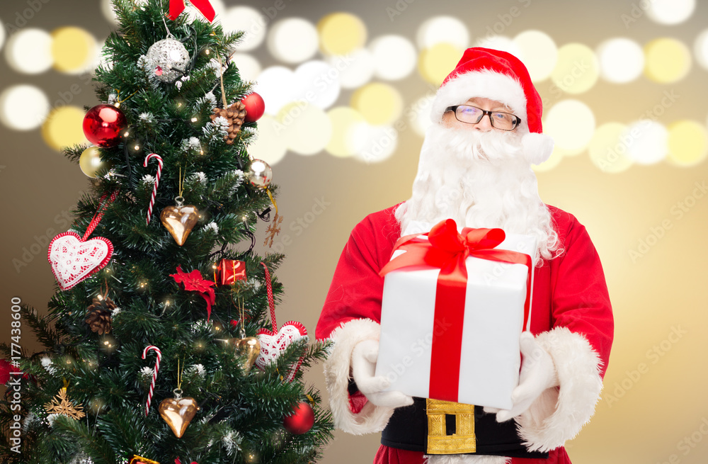 santa claus with gift box at christmas tree santa claus with gift box at christmas tree