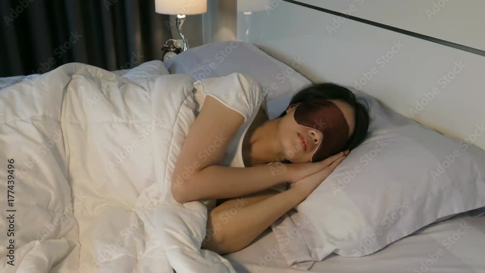 4k of Beautiful young woman sleeping with sleep mask in her bed at home 4k of Beautiful young woman sleeping with sleep mask in her bed at home