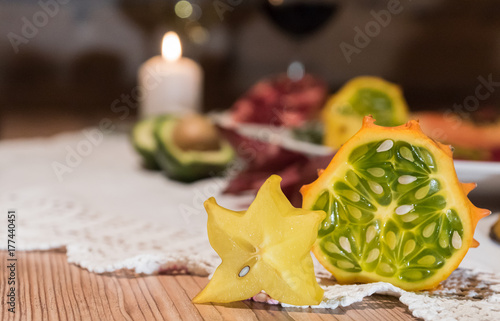 Obraz na płótnie Sternfrucht und Kiwano mit Kerzenlicht im Hintergrund w salonie