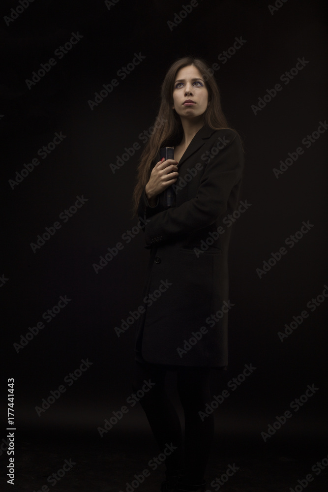 Girl with long hair and a book on a black background Girl with long hair and a book on a black background