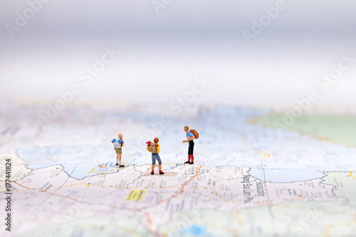  Miniature Group traveler with backpack standing on wold map for travel around the world. Travel Concept, select focus.
