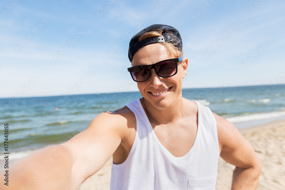 man in sunglasses taking selfie on summer beach man in sunglasses taking selfie on summer beach