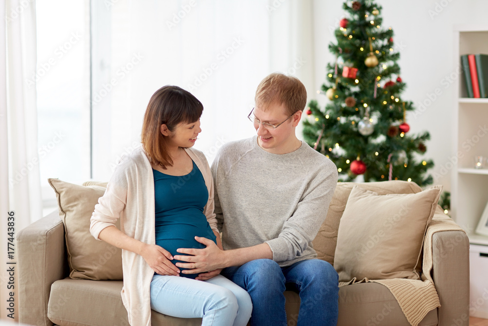 pregnant wife with husband at home at christmas