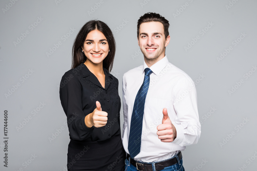 A portrait of a businesswoman and a businessman standing and showing ok isolated on grey A portrait of a businesswoman and a businessman standing and showing ok isolated on grey
