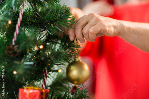 close up of senior woman decorating christmas tree