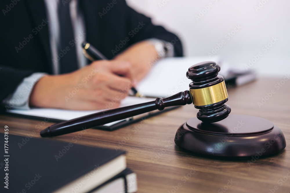 Gavel on wooden table and Lawyer or Judge working with agreement in Courtroom theme, Justice and Law concept Gavel on wooden table and Lawyer or Judge working with agreement in Courtroom theme, Justice and Law concept