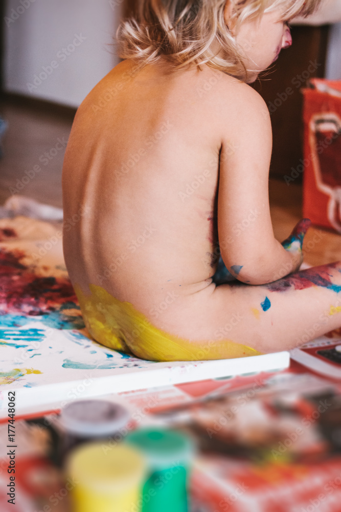 toddler painting on canvas with his butt Stock Photo
