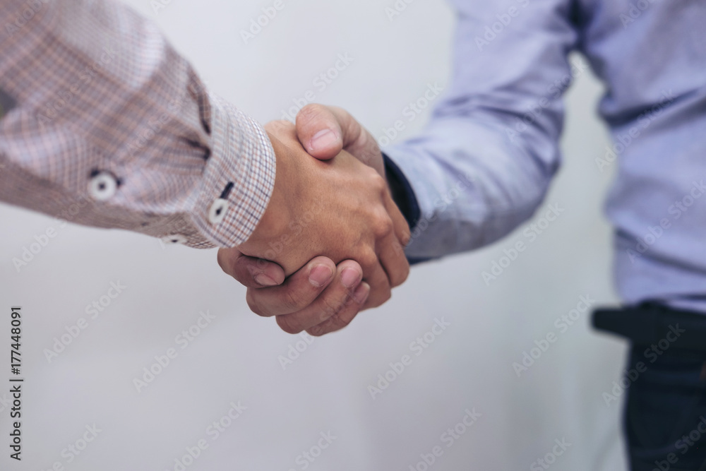 Two businesspeople shaking hands during a meeting in the office, success, dealing, greeting & business partner concepts - selective focus. Two businesspeople shaking hands during a meeting in the office, success, dealing, greeting & business partner concepts - selective focus.