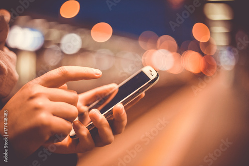 Young woman calling on a mobile at train station during early morning (shallow DOF, color toned image)