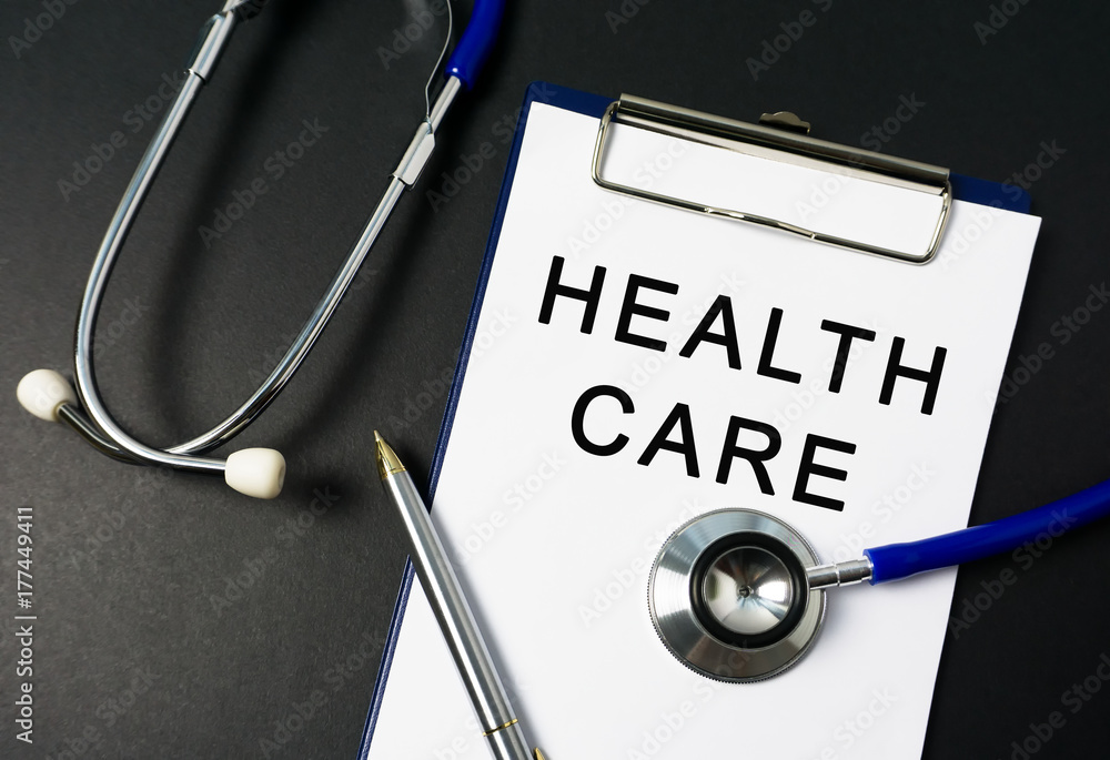Health care word on paper with stethoscope on black background Health care word on paper with stethoscope on black background
