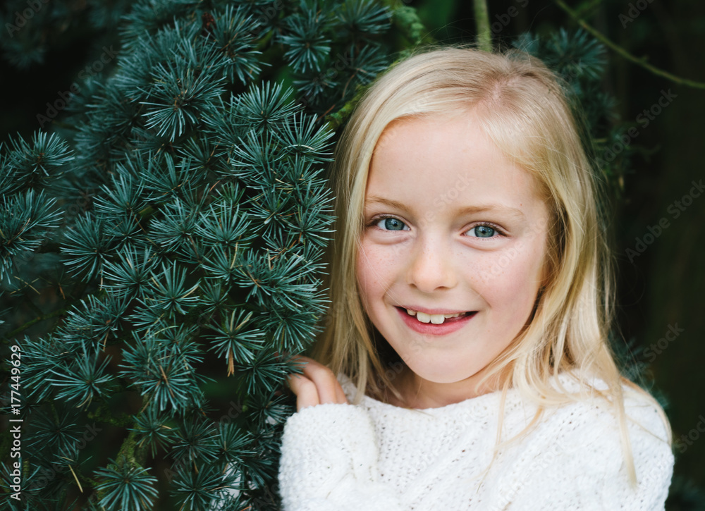 A smiling little girl and a fir tree. A smiling little girl and a fir tree.