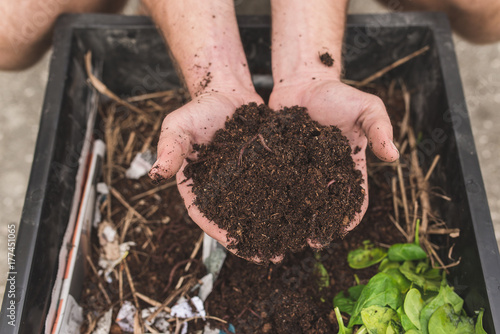 A Close Up Of A Man Holding Compost And Worms