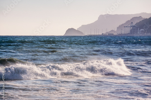 Beautiful blue sea and waves with industrial background