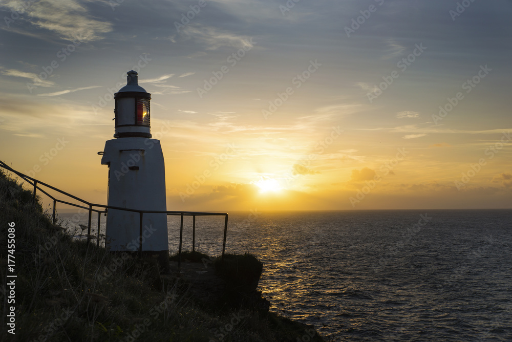 Lighthouse by the sea at sunrise, Polperro, Cornwall, UK
