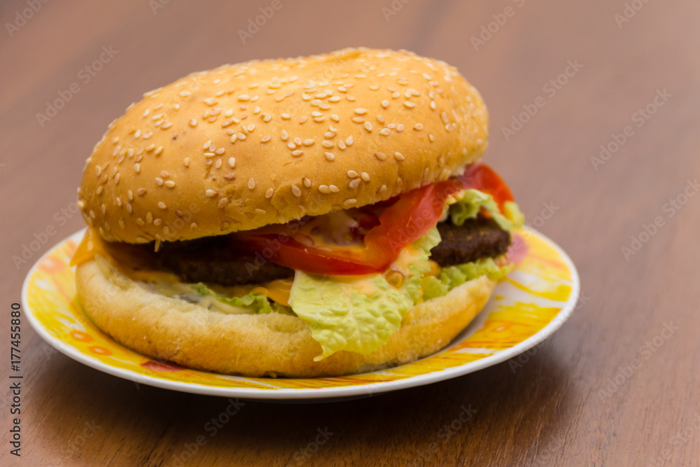 Delicious hamburger or sandwich on plate on wooden table