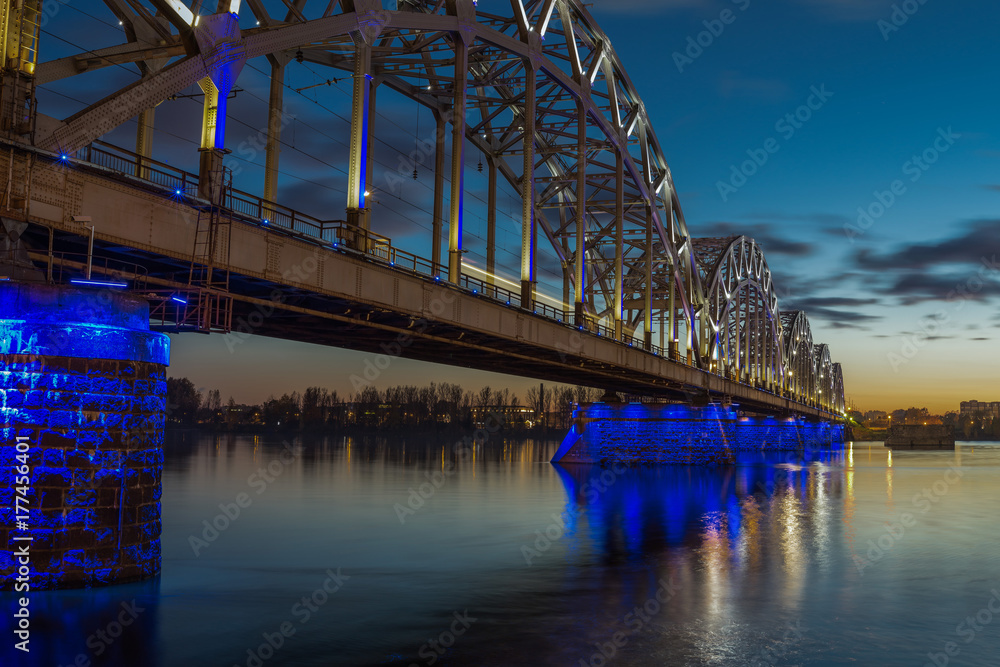 Obraz premium Illuminated railway bridge at twilight in Riga