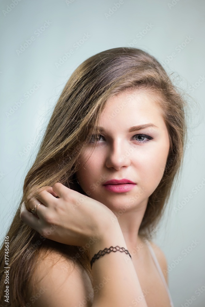 Fototapeta premium Young beautiful girl touching hair