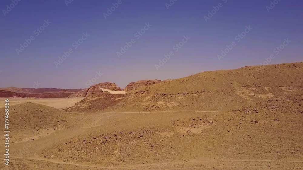 Aerial view of the sand dunes and mountain. Desert at sunset - mountain landscape with dust. Aerial view of the sand dunes and mountain. Desert at sunset - mountain landscape with dust.