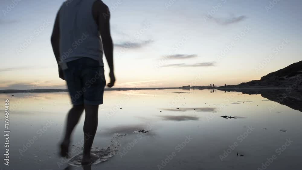 Beautiful sandy beach at sunset with people walking in the distance Beautiful sandy beach at sunset with people walking in the distance