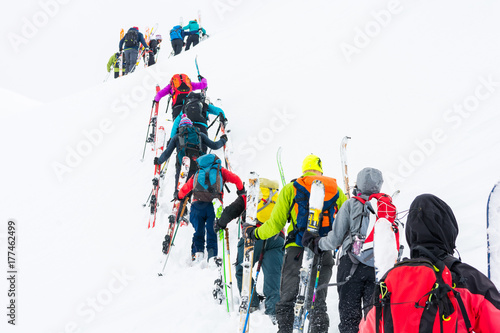Group of cross-country skiers ascending a steep slope. photo